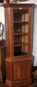 Arts & Crafts style mahogany standing corner cabinet with glazed upper section, having three