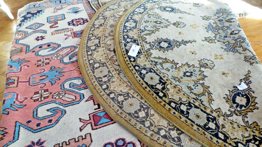 Wool rug with ivory ground, central pink medallion with light blue and pink borders and two other