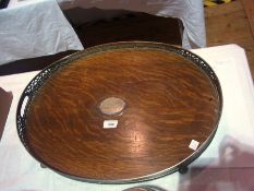 Large oval silver plate tray, fretwork gallery, two handles, silver escutcheon centre of wooden base