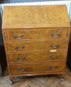 Reproduction figured walnut bureau with four long drawers, on stump cabriole supports