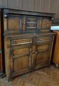 Reproduction oak court cupboard, the top section with central linenfold carved door, similarly