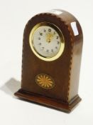 A small mantel clock in an inlaid mahogany domed shaped case, height 16cms