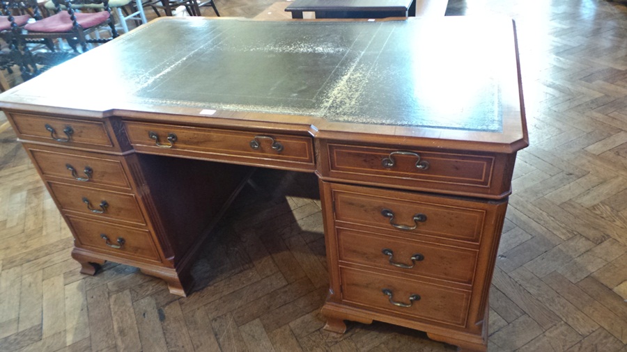 Reproduction yew wood partner's desk, the shaped top with gilt tooled leather, fitted arrangement of