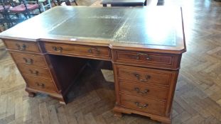 Reproduction yew wood partner's desk, the shaped top with gilt tooled leather, fitted arrangement of