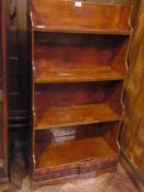 Lacquered and painted waterfall bookcase having two drawers to base faced as books