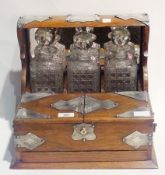 Victorian presentation tantalus dated 1891, with three square cut decanters with stoppers, mirror