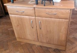 Modern light hardwood cupboard with two drawers, cupboard below, all with curved metal handles