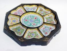 A Chinese enamel serving set with central dish and eight small bowls, in an octagonal papier mache