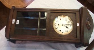 Early twentieth century oak cased wall clock with silvered dial and glazed panel door, striking