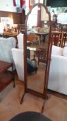 Reproduction mahogany cheval mirror with shaped arch top, on scroll base