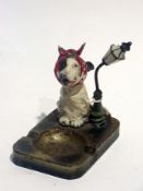 Early 20th century metal novelty ashtray surmounted by a terrier, man's best friend, suffering