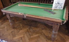 Oak snooker table on large turned supports with three cues, scoreboard and a quantity snooker balls