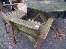 A wooden folding garden table together with a tete a tete garden seat