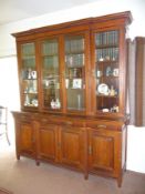 An Edwardian walnut breakfront bookcase on cupboard, knurled moulded cornice above four glazed