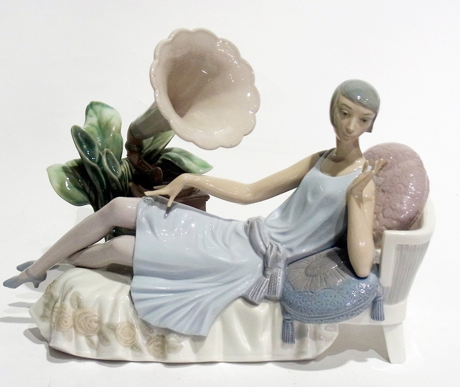 Lladro porcelain figure of a seated 1920's flapper on chaise longue,  with clockwork gramophone,