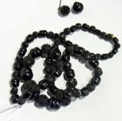 Carved jet necklace of stylised foliate carved beads and plain beads, all graduated and matching