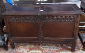 An antique oak coffer, with panelled hinged lid, carved panelled front on square supports, 96cm wide