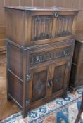 A modern oak drinks cabinet, with hinged top, drawer and cupboards below, on straight supports, with