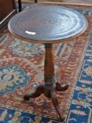A circular lacquered tripod table, with Middle Eastern style decoration, 36cm in diameter