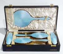 A George V silver and blue enamel backed dressing table set, comprising:- handmirror, pair