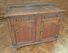 An oak sideboard with pair of drawers above two panelled cupboards, on bun feet, 121cm wide