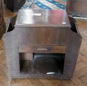 A modern oak sewing box, with hinged lid, drawer below flanked by two magazine racks, 60cm wide