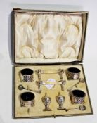 A George V silver cruet set, comprising:- four open salts with fretwork decoration, on bun feet with