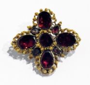 Victorian gold-coloured metal and garnet brooch, quatrefoil central circular stone, filigree border