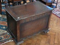 A modern oak chest, with hinged lid, carved panel front, on castors, 72cm wide