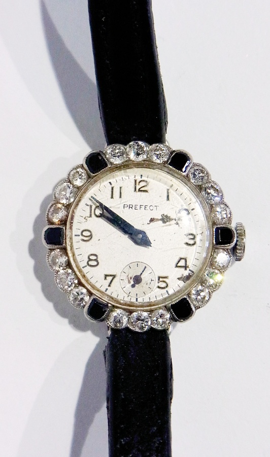 A lady's Swiss platinum diamond and black onyx wristwatch with a circular dial and arabic