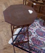 A Middle Eastern octagonal occasional table, with metal relief decoration to top, on foldout