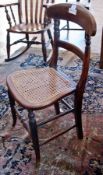 An antique cane-seated chair, with carved back-rail to cane seat on oak supports, united by