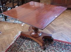 A Regency mahogany card table, on baluster shaped column, quatrefoil base, on scroll feet