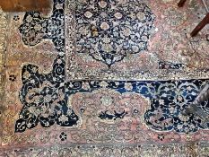 A Persian design Grosvenor Wilton carpet, with blue floral spray border, green central medallions