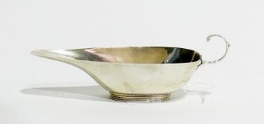 A silver sauceboat of narrow oval form, with C-scroll handle, raised on a reeded foot, Birmingham