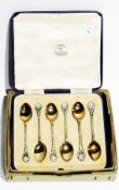 A George V silver gilt and inlaid enamel set of six coffee spoons, with flowerhead finials, by