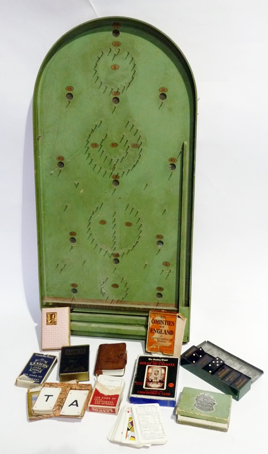 An early 20th century bagatelle board, green-painted, 75cm long  and a selection of other games,