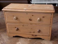 A pine low chest of two long drawers, circular wooden handles, on bracket feet, 89cm wide