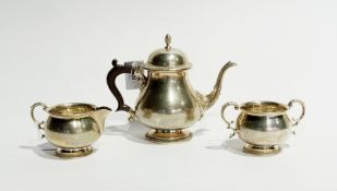 A silver three-piece teaset of plain baluster form with gadrooned borders, comprising:- teapot,