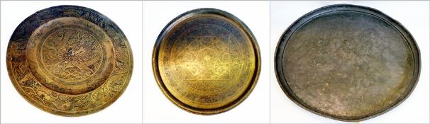 A large circular beaten brass tray, diameter 75cm, a heavy Chinese circular brass tray and an Indian