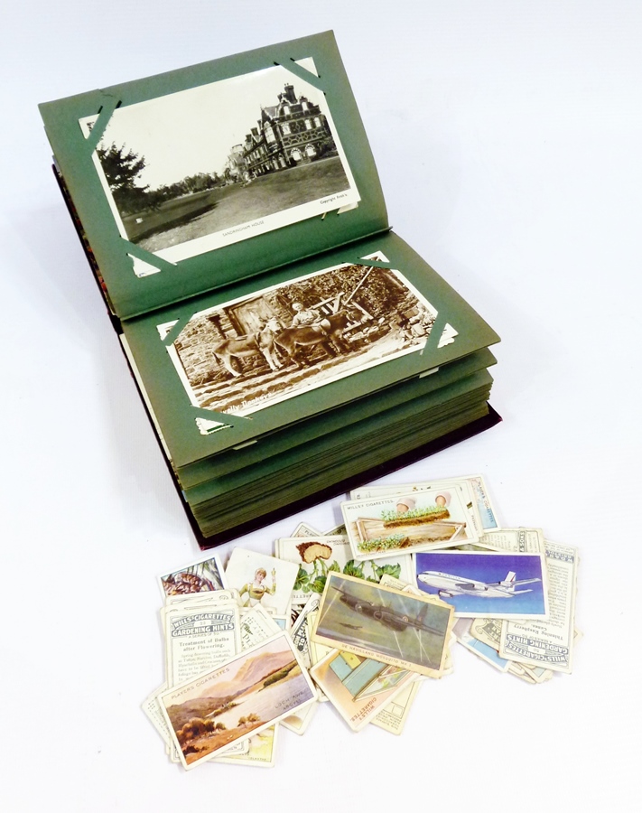 An album containing assorted mid to late 20th century postcards, a cigarette card album and a