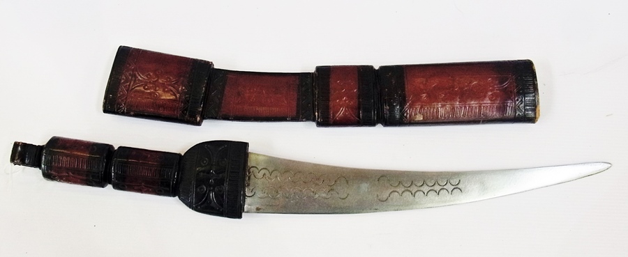 A tribal curved short sword with a leather hilt and scabbard