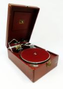 An HMV red portable wind-up gramophone, 78rpm, in a red case with carrying handle