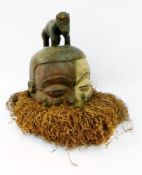 A Pende Helmet mask with painted detail and raffia, 43.5cm high approx.