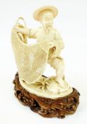 A Chinese ivory carving of a fisherman casting his net, on a naturalistic carved wooden base, height