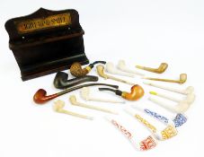 Quantity clay and other pipes, wooden pipe rack with brass plate inscribed "Light up and smile", and