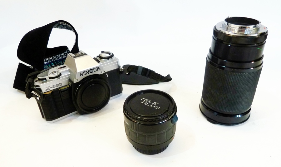 A Minolta X300 35mm SLR camera together with a 28-200mm zoom lens and another lens in a case