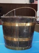 Antique brass-bound oak bucket with copper swing handle and triple brass banding