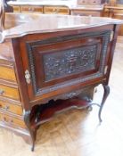 An Edwardian mahogany corner cabinet, with relief carved panel front of fruit in urn, on cabriole