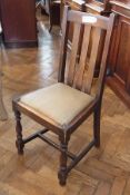 A set of four oak slatback dining chairs with inset leather seat, on turned supports, cross